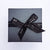 Black box packaging with Lily Gardner logo in silver on black ribbon bow